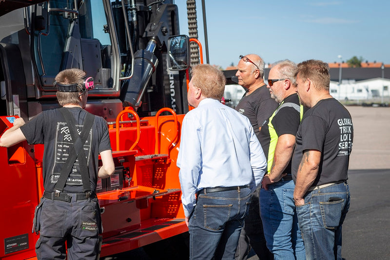 Servicechef Lars-Erik Hedberg och servicetekniker Linus Åberg från Ottosson Truck samt och servicetekniker Ronnie Myhrvold och säljare Jörgen Falk går igenom trucken tillsammans med kund. Trucken är kundprofilerad i Byggelements orangea färg.